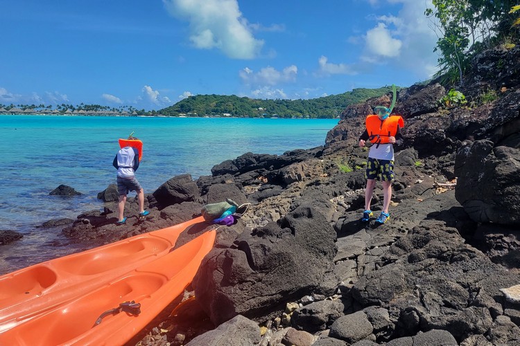 family kayaking from Bora Bora mainland to aquarium snorkeling spot
