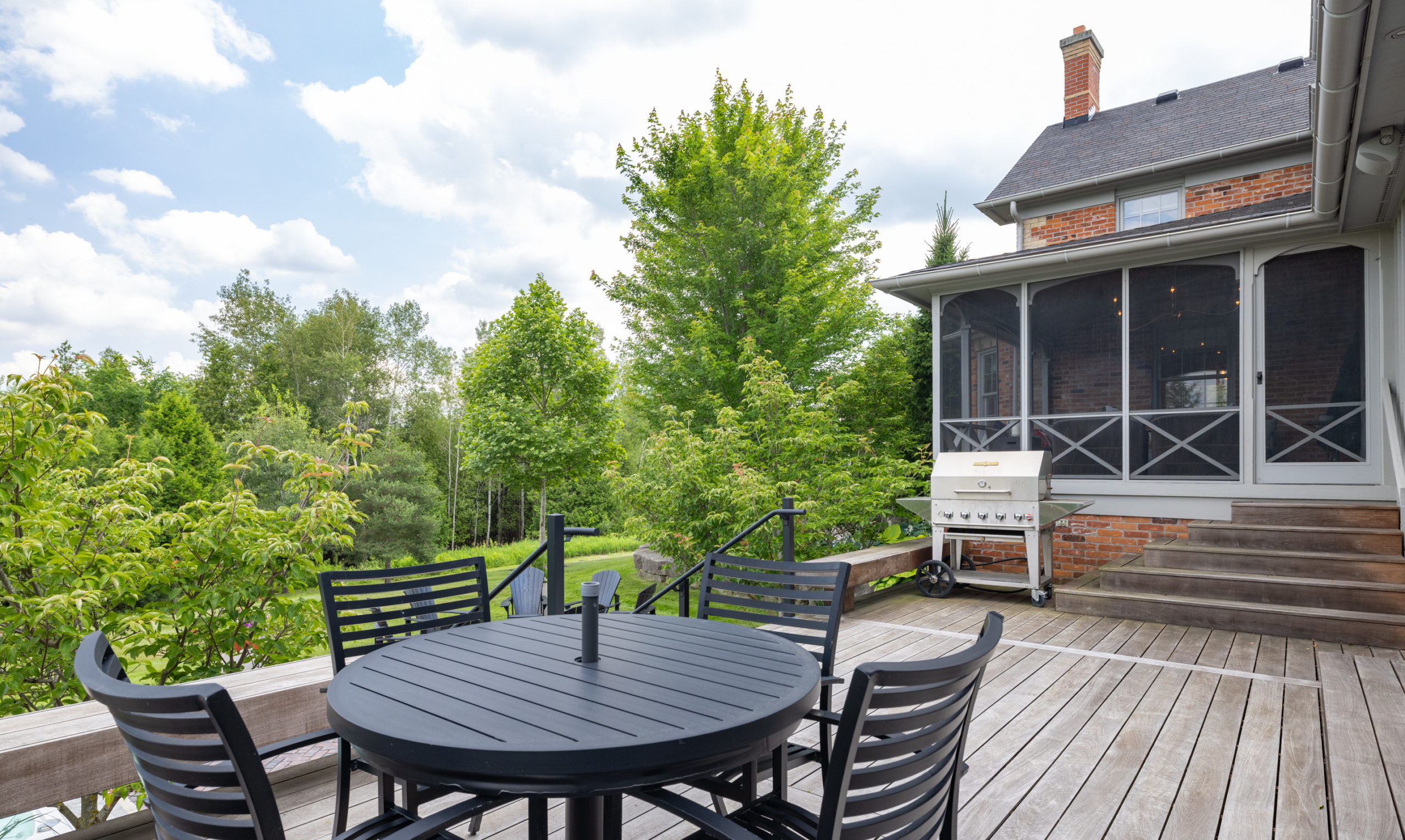 The large deck descends from the three-season room and comes with a grill and dining area. 