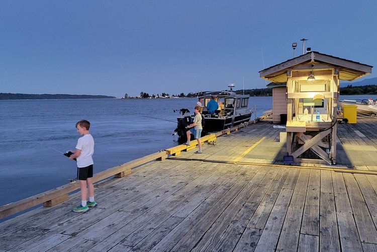 boys fishing off the dock at Painters Lodge fishing resort in Campbell river on Vancouver island, British Columbia