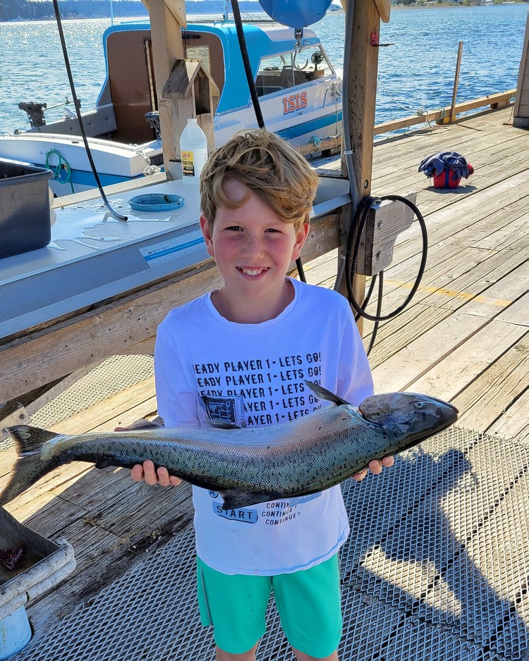 Campbell River Salmon Capital of the World, fishing excursion from Painter's Lodge resort in Campbell River British Columbia, kid holding a chinook salmon on the dock