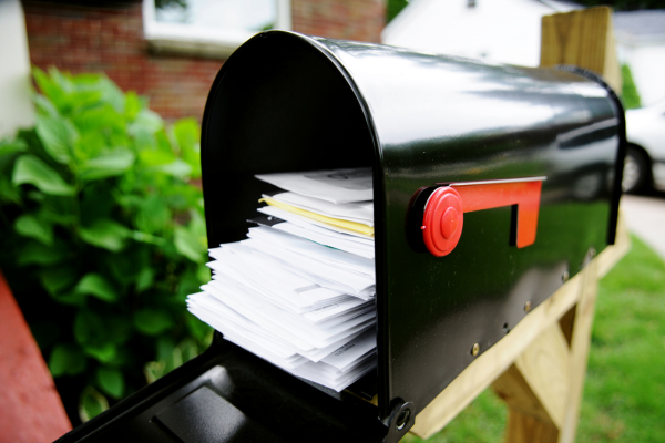 A outdoor mailbox is stuffed with unopened mail. A credit card mistake to avoid is not opening and reading your statements.