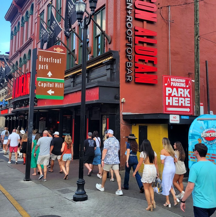 tourists walking on Broadway Street Nashville in front of Jason Aldean's Kitchen and Rooftop Bar