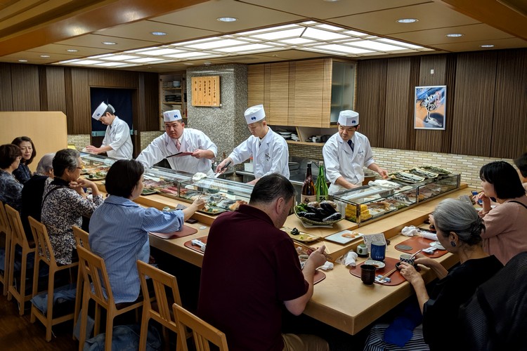 Sushi chefs inside a Japanese restaurant in Tokyo serving sushi and Japanese cuisine