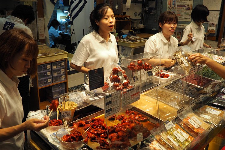 store at Nishiki Market selling red baby octopus on a skewer, interesting food in Japan for tourists