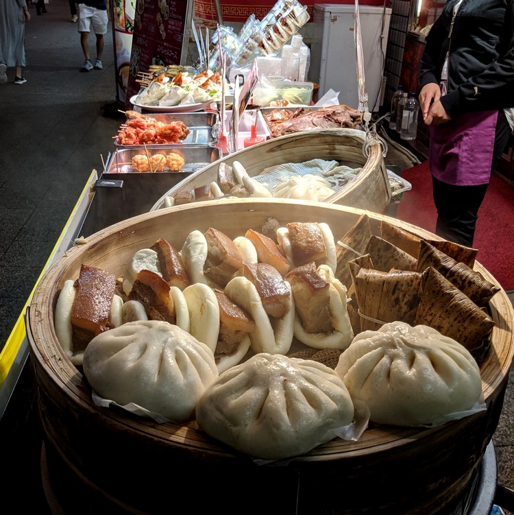 A vendor in Kobe Chinatown sells a variety of street food, including fatty pork buns