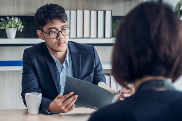 An interviewer is reviewing a job candidates credentials.