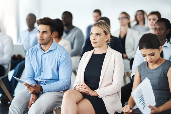 A group of professionals sit in a seminar to develop their professional credentials.