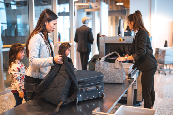 A mother and her young children are going through security at an airport.