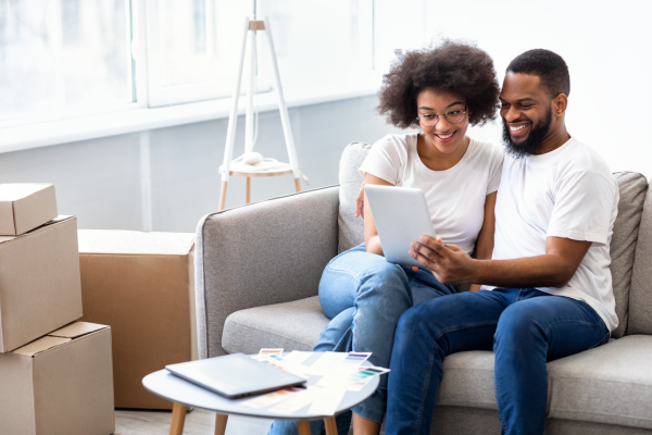 A young couple is using a tablet to search for housing.